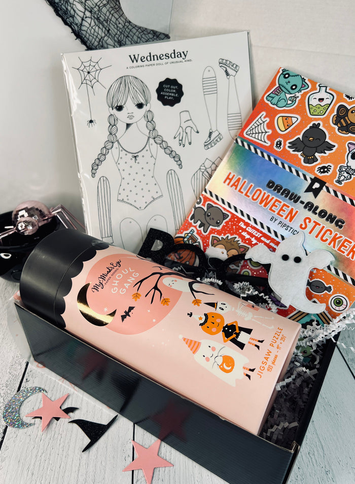 A gift box with various Halloween-themed items including a sticker book, a puzzle, glasses, and a coloring sheet, wrapped with a ribbon and tagged with 'Creative Wednesday'.