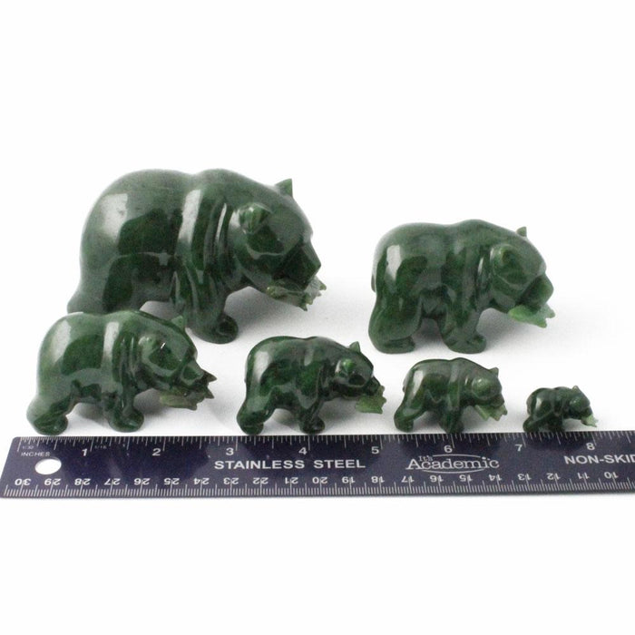 Group of green bear figurines in different sizes with a ruler for scale