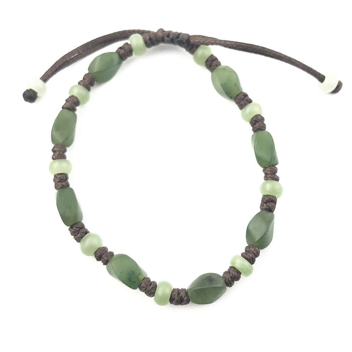 Bracelet with green stone chips and pale green beads on a dark braided cord.