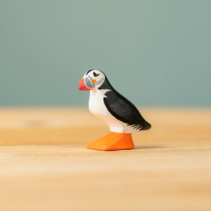 Model of a puffin on a sandy surface with a blurred green background