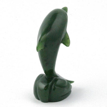 Green dolphin figurine viewed from the side with tall curved body on a rounded base