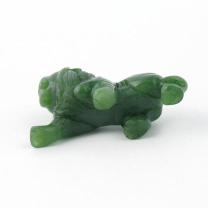 Green stone lion figurine lying on its side