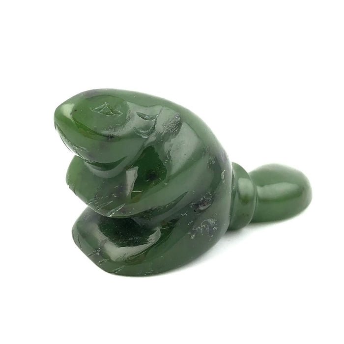 Close-up of green nephrite jade beaver sculpture with polished surfaces on a white background.