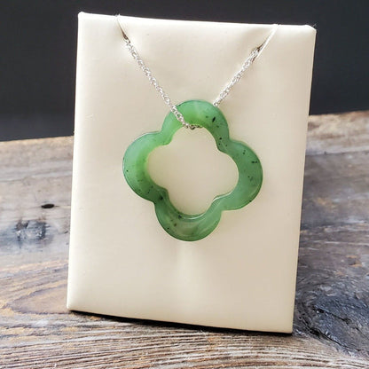 Green clover pendant on a silver chain displayed against a white display card.