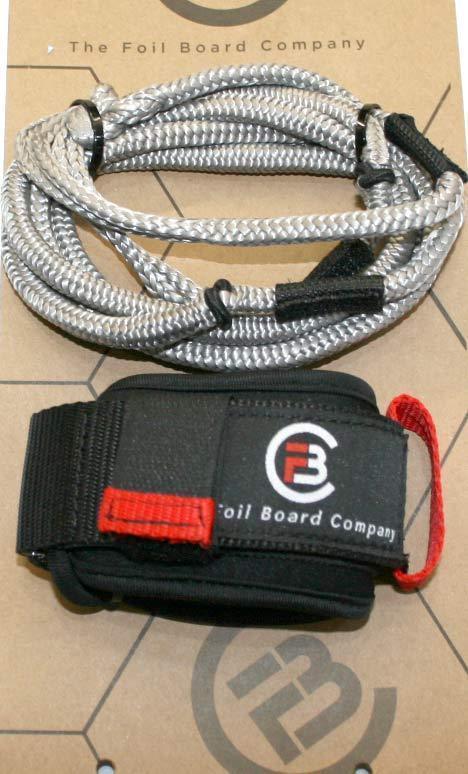 The Foil Board Company wing foil leash with black wrist strap, red accent, and silver braided cord