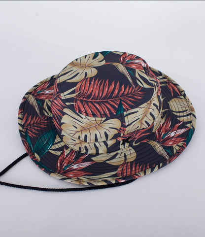 Tropical leaf print bucket hat with black chin strap, ideal for watersports and beachwear