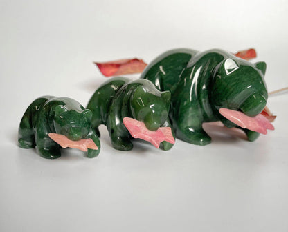 Three green jade bear figures with pink rhodonite fish on a white background
