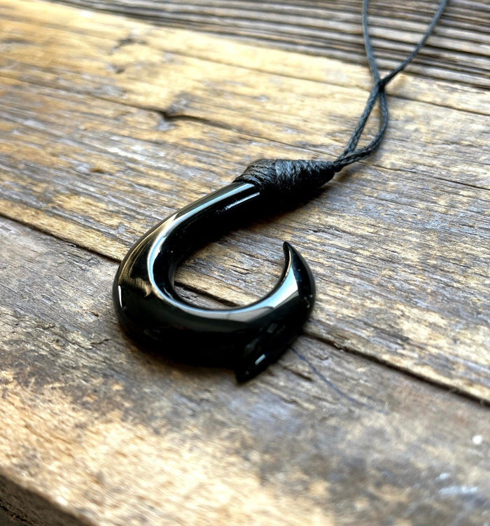 Black jade fish hook pendant on a black cord