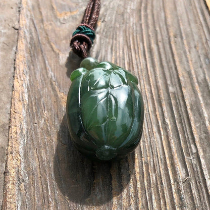 Close-up of green jade squash pendant showing detailed leaf carving.