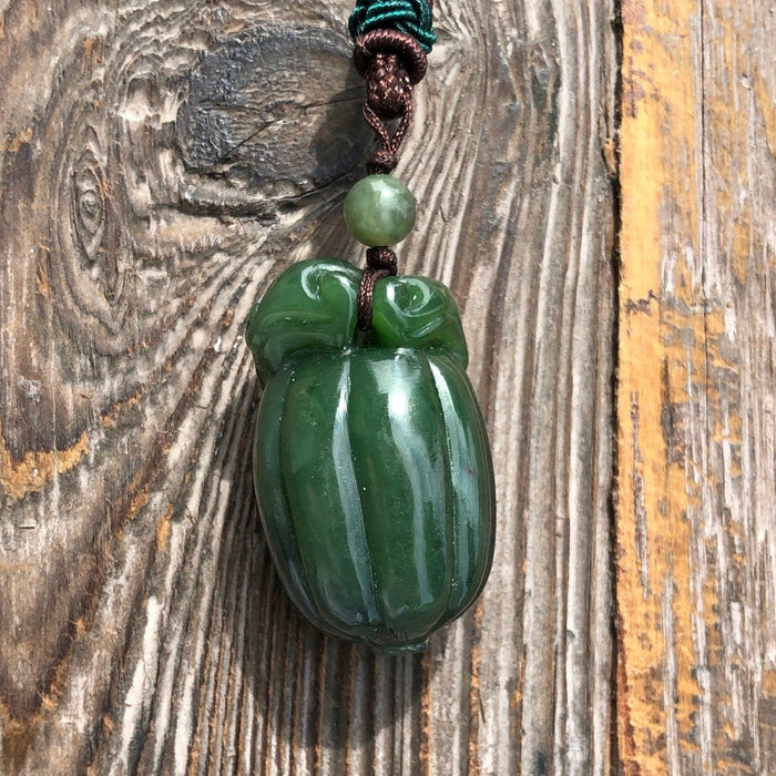 Close-up of jade squash pendant 35mm on braided cord with a small green bead above.