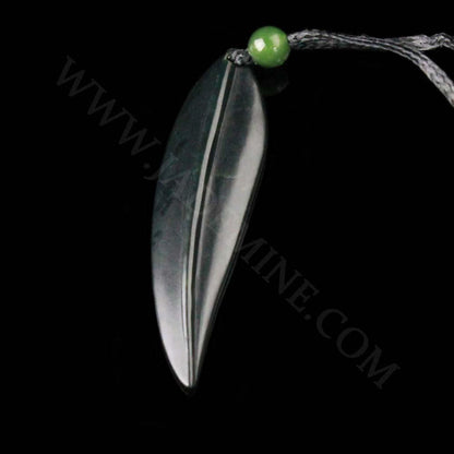 Leaf pendant on a black cord with a green bead, side view of the dark elongated leaf