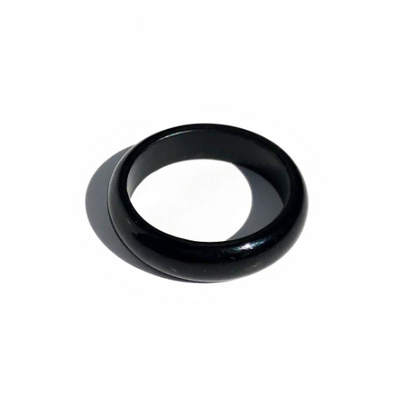 Glossy black jade ring with a smooth rounded band on a white background.