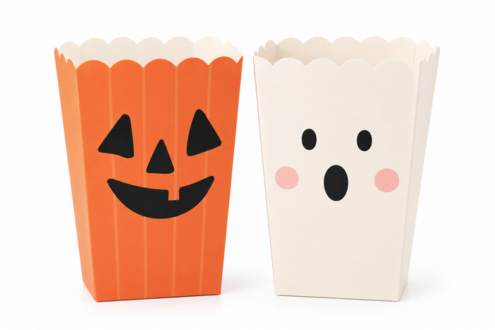 Two Halloween-themed popcorn boxes on a white background, one orange with a black jack-o'-lantern face and one off-white with a surprised face and pink cheeks.