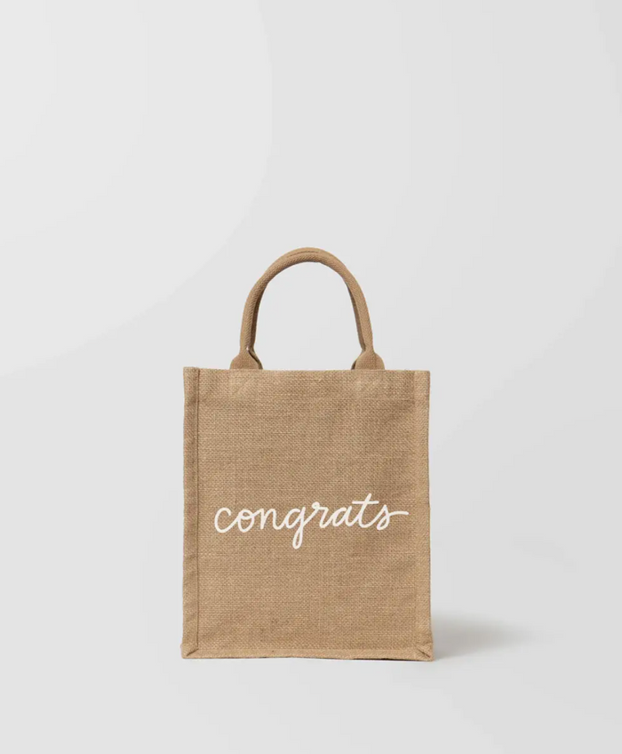 A beige cotton tote bag with the text 'CONGRATS' printed on the front.