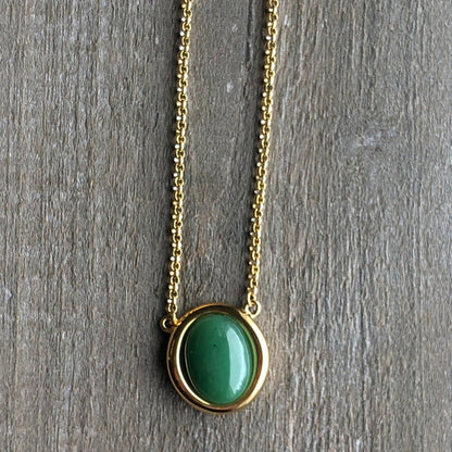 Gold-tone chain necklace featuring a round green jade pendant in a gold bezel