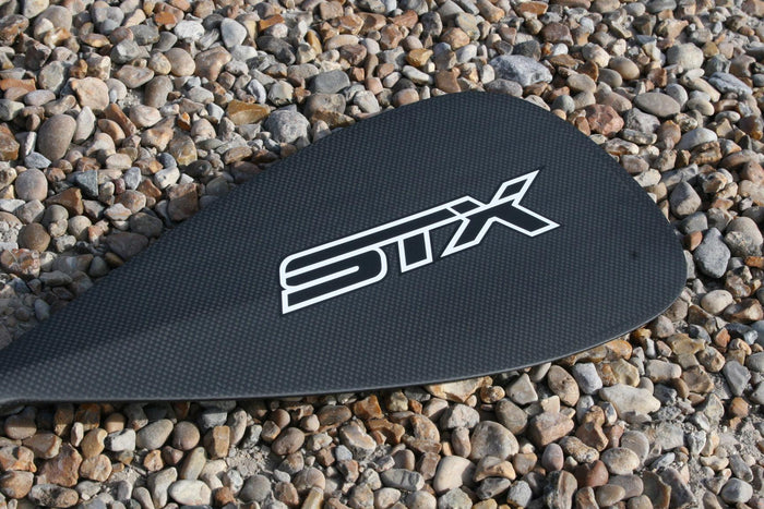 STX Carbon 80% 3-piece SUP paddle blade on pebbles