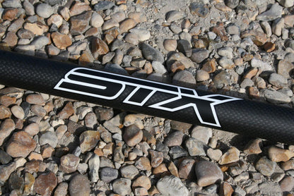 STX Carbon 80 Percent 3 Piece SUP paddle with carbon fiber shaft on gravel