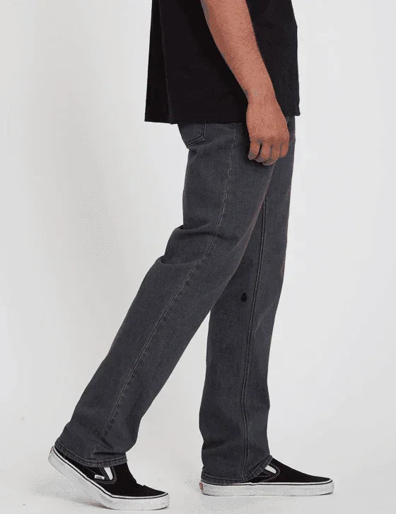 Black Vans sneakers paired with dark gray jeans, casual streetwear style