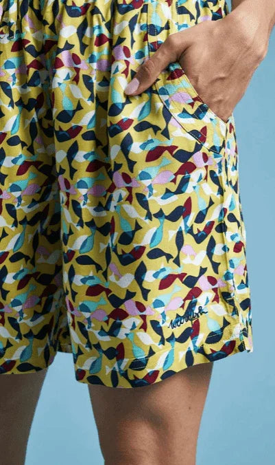 Vibrant yellow board shorts with colorful fish print, ideal for watersports at Boardworx Whitstable.