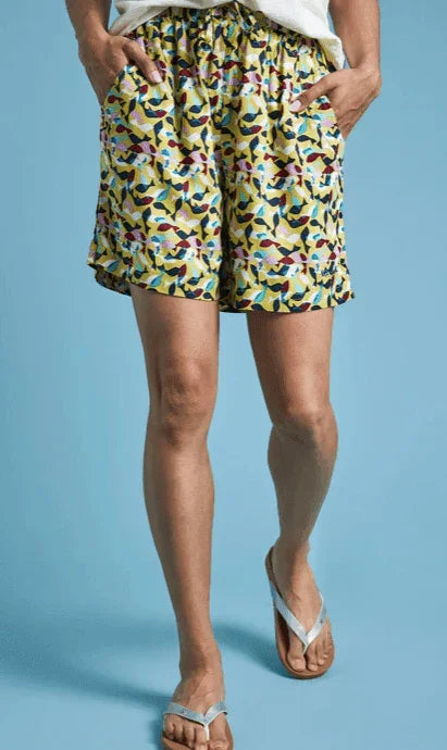 Colorful patterned beach shorts with yellow base, ideal for watersports and summer wear.