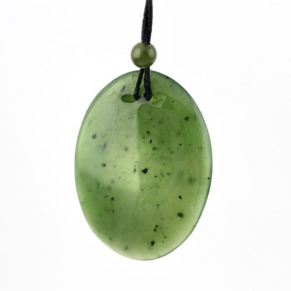 Oval green jade pendant on a black cord with a small green bead above